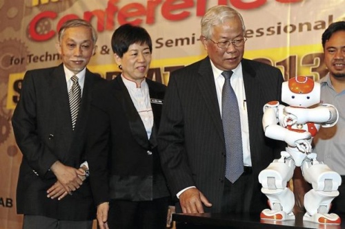 Pretty hi-tech: (From left) Abang Abdullah, Politeknik Kuching director Clara Ong and Manyin watching a dancing robot at the opening of the conference in Kuching. — ZULAZHAR SHEBLEE / The Star