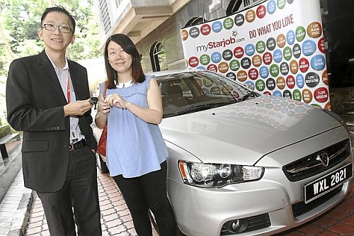 Lucky jobseeker: Tee receiving the keys to her Proton Inspira from Serm during the prize presentation ceremony at Menara Star in Petaling Jaya.