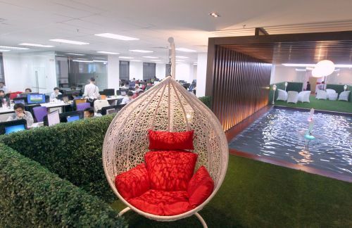 A discussion cum lounge area complete with faux grass, garden chairs and a water feature sits in the center of the office.
